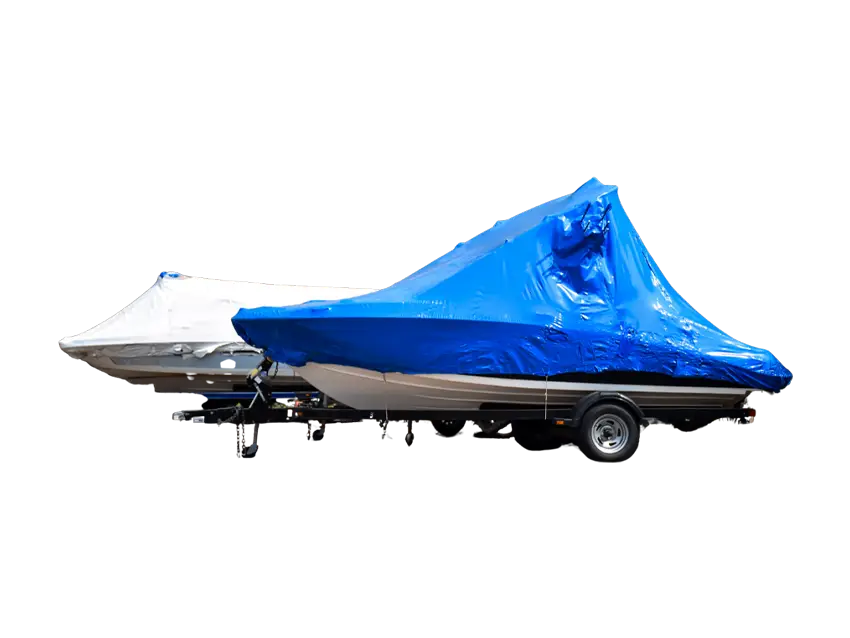 Zwei Boote auf Anhängern, abgedeckt mit Schrumpfhauben und Folien-Beutelprodukten zum Schutz vor Witterungseinflüssen.