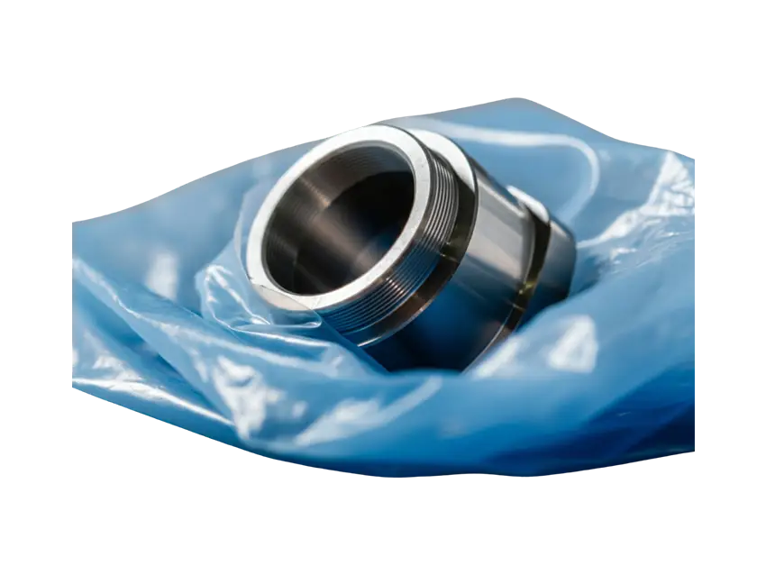 Korrosionsschutz Seitenfaltenhauben: Metallbauteil, verpackt in blauer Schutzfolie, Nahaufnahme für Korrosionsschutz.