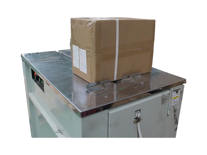 Paletten Warensicherung Umreifungsmaschine: A cardboard box secured with strapping on a strapping machine.