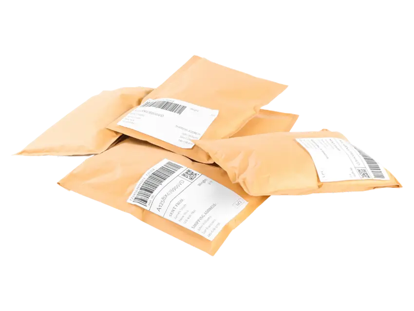 Versandartikel Versandtaschen: Mehrere braune Versandtaschen mit Adressetiketten liegen gestapelt auf einem schwarzen Hintergrund.